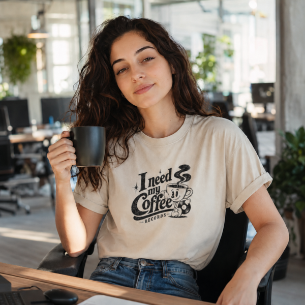 Une femme porte le t-shirt I need my Coffee Records blanc, dans un open space