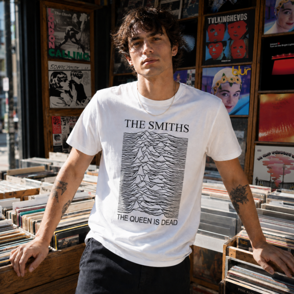 Jeune homme portant le t-shirt blanc The Smiths Unknown Pleasures devant un magasin de disques